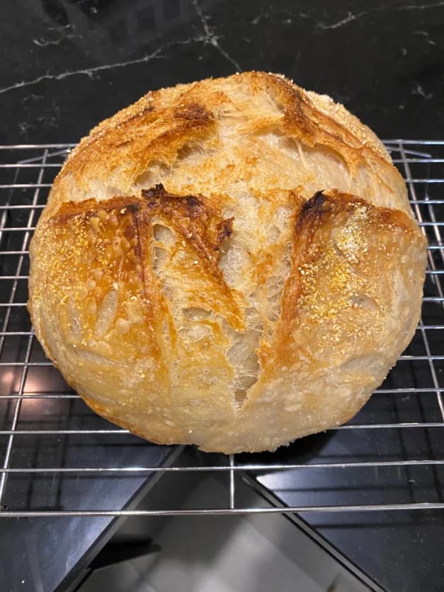 A finished sourdough loaf on a wooden counter